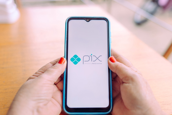 Mercado Pago: mãos segurando um celular para definir um novo limite Pix. 