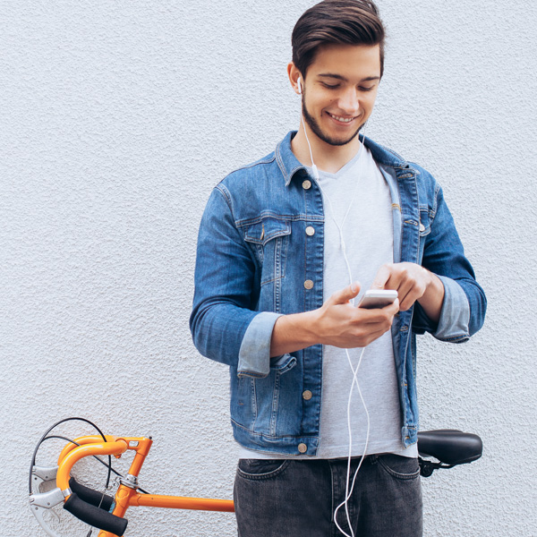 Homem apoiado em bicicleta usando o celular